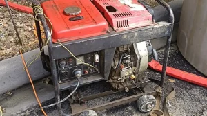 Groupe électrogène portable rouge en usage extérieur, câbles branchés